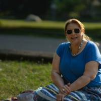 woman seated on the ground on blanket smiling